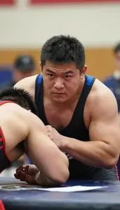 Arm Wrestler In Tank Top And Determined Expression Straining