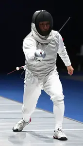 Fencer In Full White Protective Gear And Mask Lunging