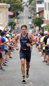 Triathlete In A Trisuit And Race Belt Runs Up A Steep Hill