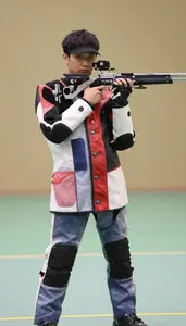 Air Rifle Shooter In Shooting Jacket And Specialized Pants