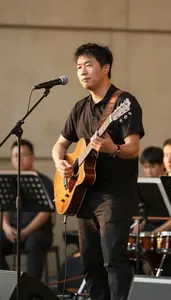 Announcer Playing Guitar On A In A Concert Hall Orchestra Pit In Professional