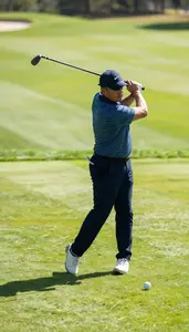 Golf Instructor Swinging A Golf Club On A Golf Course Green At Professional