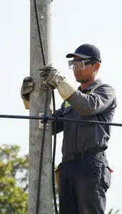 Lineman Installing Telephone Lines On On Top Of A Utility Pole In Professional