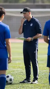 Soccer Coach Coaching A Soccer Team On A Soccer Field During Practice At Work