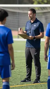 Soccer Coach Coaching A Soccer Team On A Soccer Field During Practice At