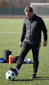 Soccer Coach Kicking A Soccer Ball On A Soccer Match Field In Professional