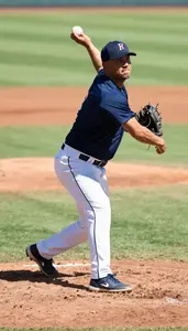 Baseball Coach Pitching A Baseball On On A Baseball Diamond At Work Today