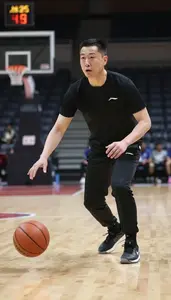 Basketball Coach Dribbling A Basketball On On A Basketball Court At Work Today