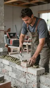 Concrete Worker Laying Bricks With Mortar In A Masonry Construction Area At