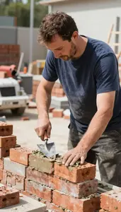 Mason Laying Bricks With Mortar In A Masonry Construction Area In Professional