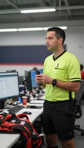 Referee Photographing A Sports Event In A Sports Analytics Office In
