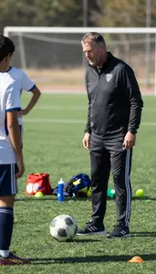 Soccer Coach Coaching A Soccer Team On A Soccer Field During Practice In