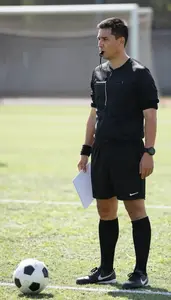 Soccer Coach Refereeing A Soccer Match On A Soccer Field During Practice At