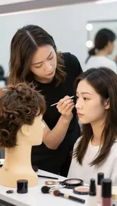 Wig Stylist Applying Professional Makeup To In A Wig Styling Workshop At Work