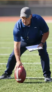 Football Coach Tackling A Football On On An American Football Field At Workplace