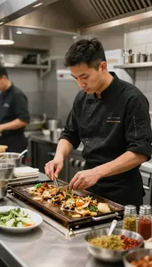 Grill Cook Preparing Dishes In A In A Busy Restaurant Kitchen In Daily Work