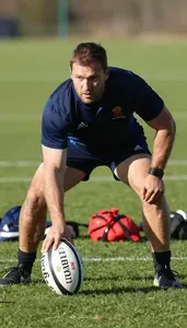 Rugby Coach Railing A Rugby Ball On A Rugby Field At Work Today