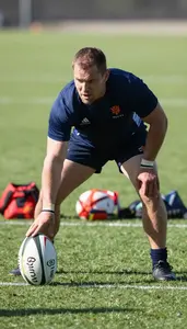 Rugby Coach Railing A Rugby Ball On A Rugby Field In Professional Environment