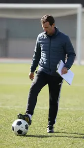 Soccer Coach Kicking A Soccer Ball On A Soccer Match Field At Professional Venue