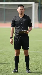 Soccer Coach Refereeing A Soccer Match On A Soccer Field During Practice In