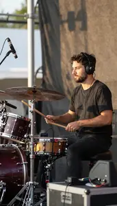Sound Engineer Playing Drums On A On A Band Performance Stage At Professional