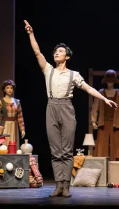 Trapeze Artist Directing An Opera Production On A Puppet Theater Stage In