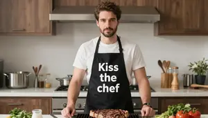 Man Grilling Steaks Wearing A Novelty Apron Saying Kiss The Chef