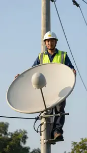 Satellite Installer Installing Telephone Lines Top Of A Utility Pole
