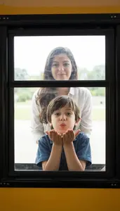 Child Blowing A Kiss To Mom From The Window Of A Schoolbus