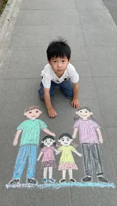 Child Drawing A Family Portrait On The Sidewalk With Chalk