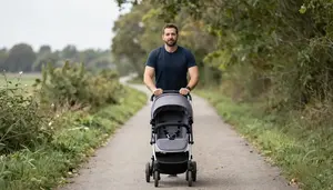 Dad Pushing A Baby Stroller While Jogging Through A Scenic Trail