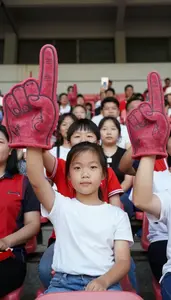 Family Cheering In A Stadium Wearing Oversized Foam Fingers Loudly