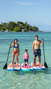 Family Paddle Boarding In Calm Turquoise Water Near A Tropical Island