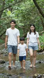 Family Walking Barefoot Through A Shallow Stream In The Woods