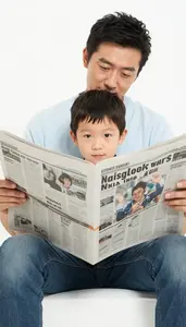 Father Reading The Newspaper While His Son Mimics Him Perfectly