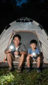 Father And Son Camping Out In A Backyard Tent With Flashlights