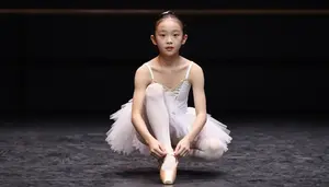 Little Ballerina Tying Her Slippers Before A Big Dance Recital