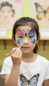 Little Girl Painting A Colorful Butterfly On A Face Painting Booth