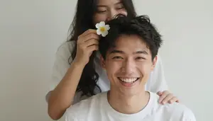 Man Laughing While His Girlfriend Puts A Flower In His Hair