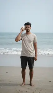Man Listening To A Seashell On A Tranquil Empty Beach Shore
