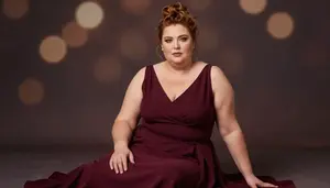Mediterranean Woman In Her 50s With Hourglass Figure With Auburn Messy Bun